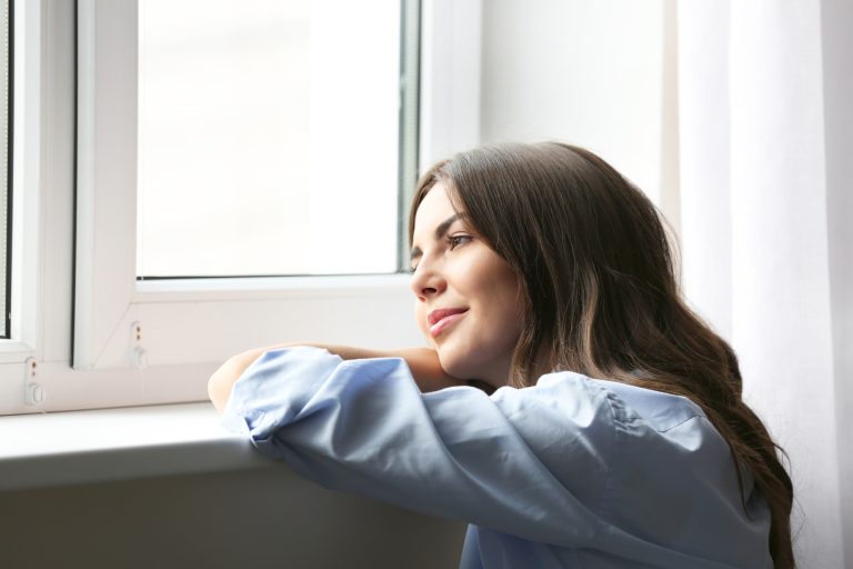 Beautiful woman looking through the window