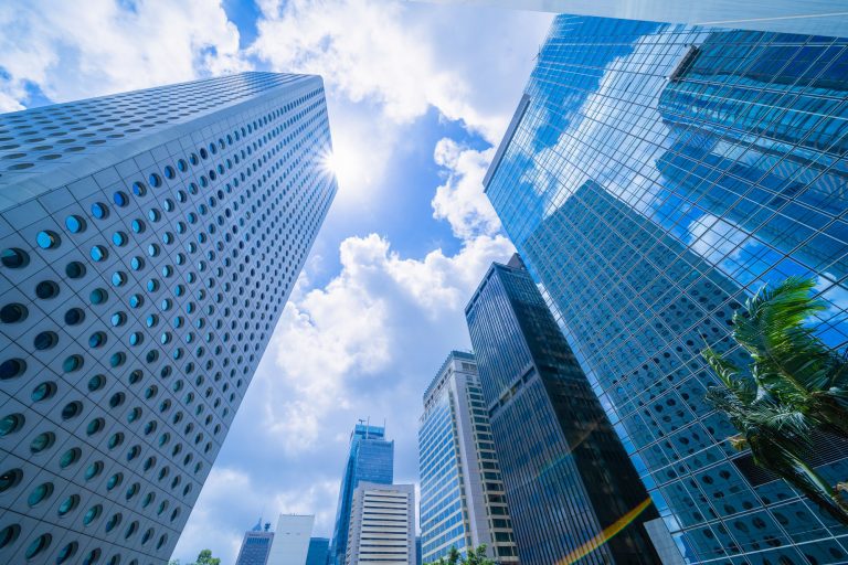 Looking up to high-rise office buildings, skyscrapers, architectures in financial district. Smart urban city for business and technology concept background in Downtown Hong Kong, China