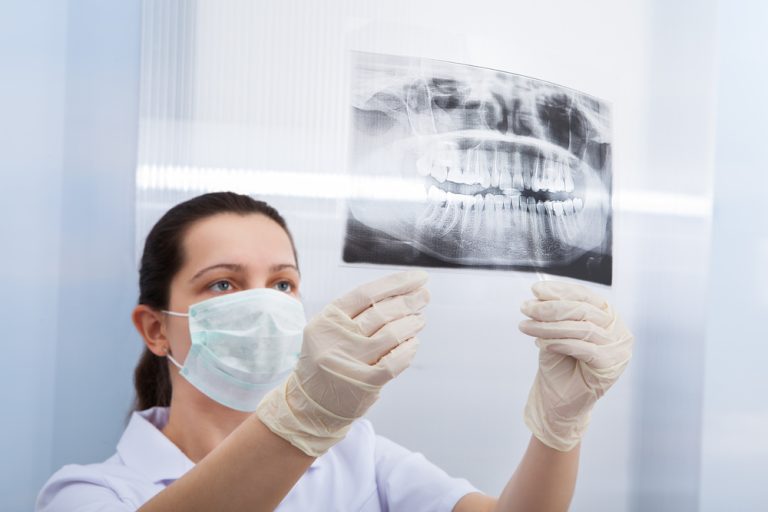 Female Dentist Looking At Dental Xray