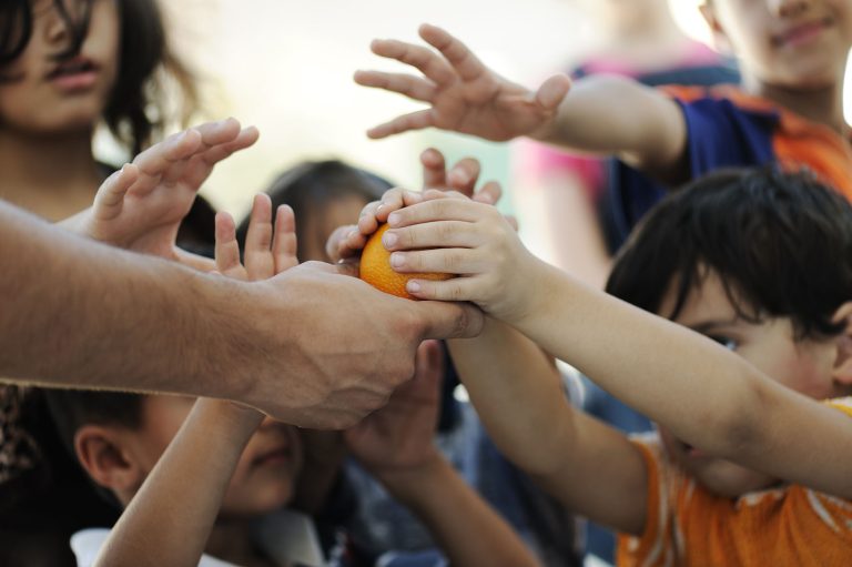 Hungry children in refugee camp, distribution of humanitarian fo