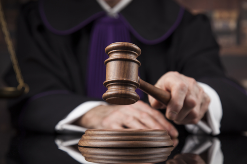 Judge, male judge in a courtroom striking the gavel