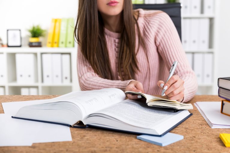 Woman working with a book and writing